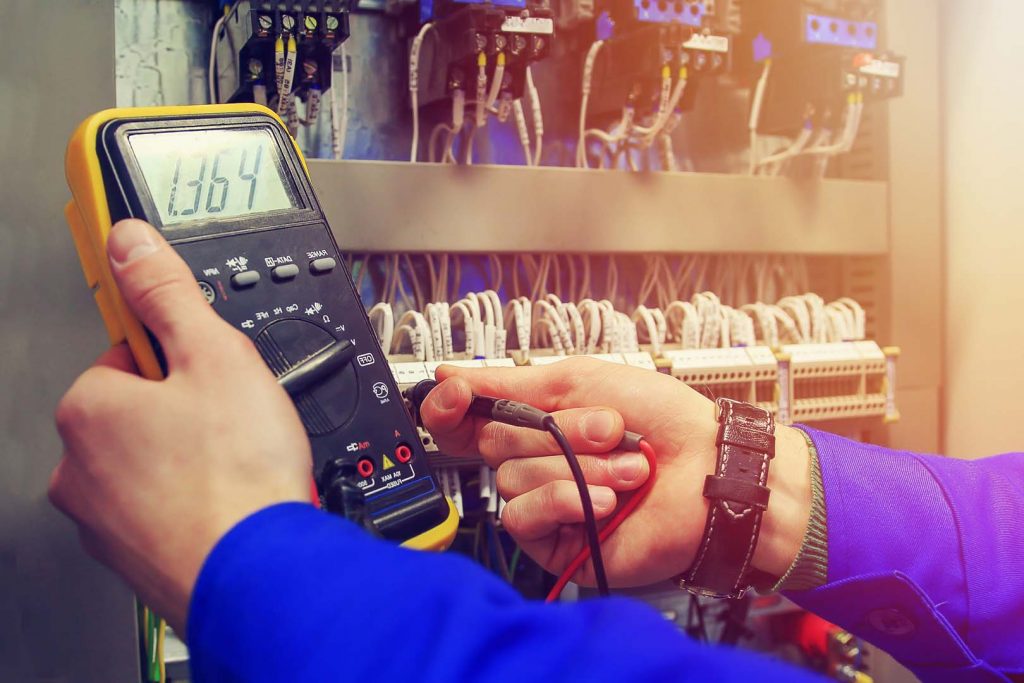 Electrician using a multimeter