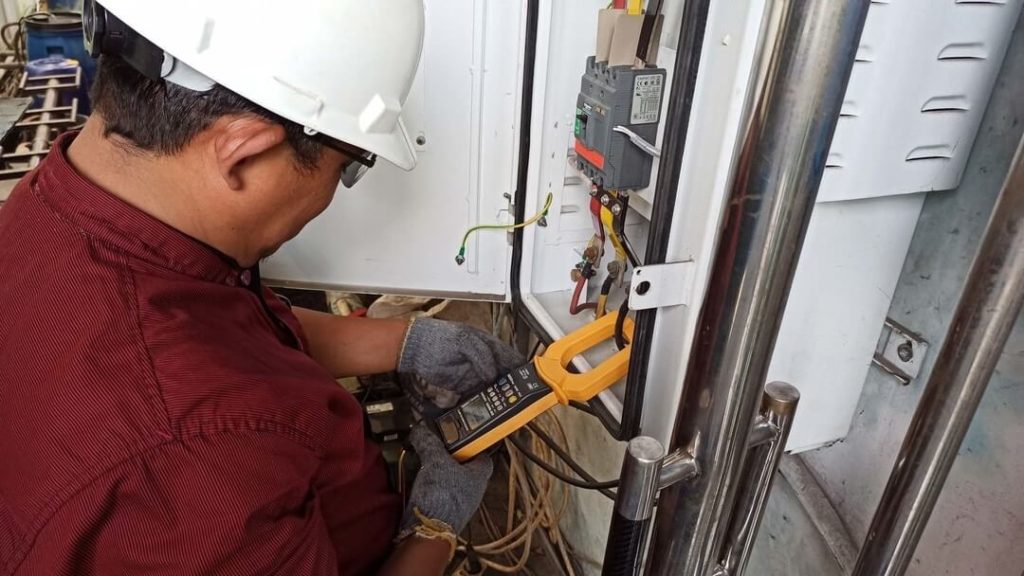 Electrician measuring power with a multimeter