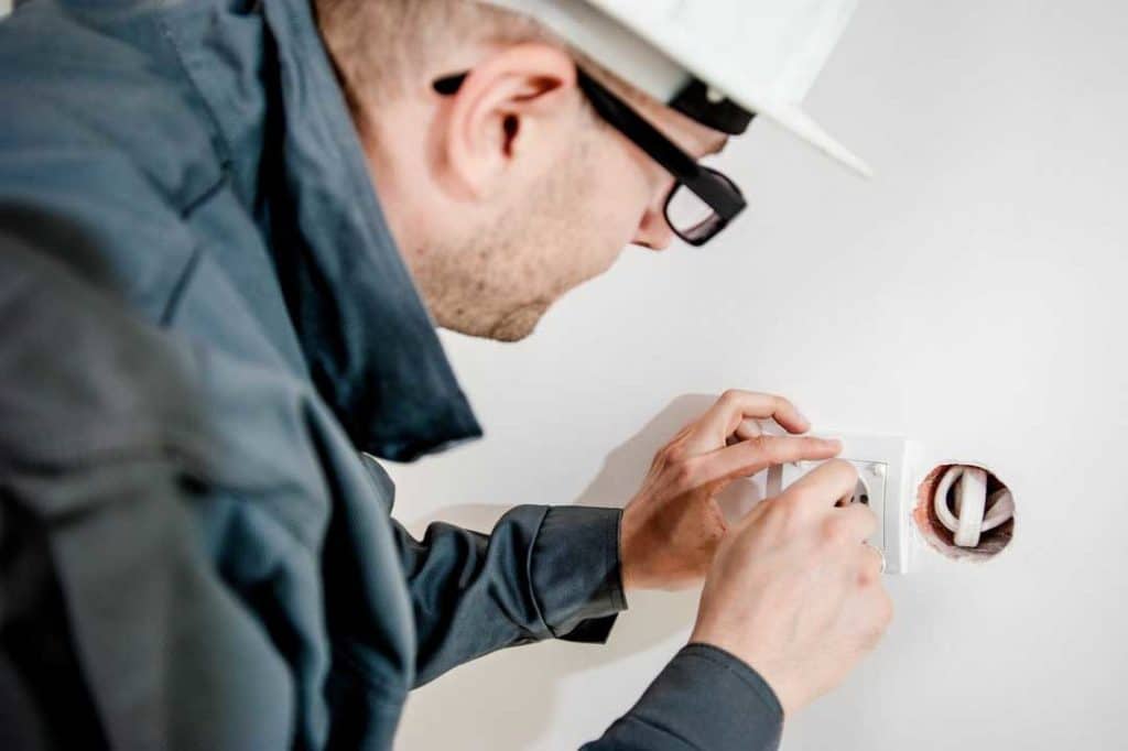 Professional Electrician fixing an outlet at home