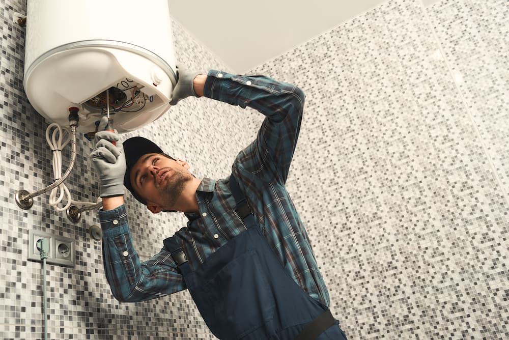 Professional plumber fixing a water boil heater.