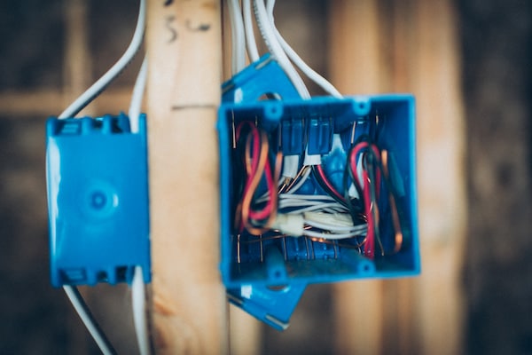 Blue electrical box with exposed wires found during electric inspection