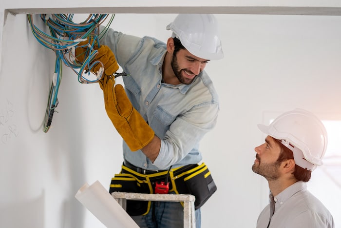expert commercial lighting installation: two electrical experts working on the cables during installation